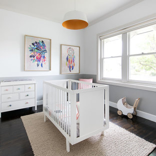 This is an example of a mid-sized transitional nursery for girls in Melbourne with multi-coloured walls, dark hardwood floors and brown floor.