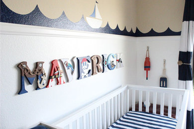 オレンジカウンティにある低価格の小さなビーチスタイルのおしゃれな赤ちゃん部屋 (マルチカラーの壁、男の子用、カーペット敷き、ベージュの床) の写真
