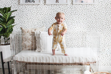 Foto de habitación de bebé neutra romántica con paredes grises, suelo de baldosas de porcelana y suelo marrón