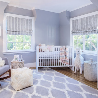 Example of a large transitional girl medium tone wood floor and brown floor nursery design in San Francisco with purple walls