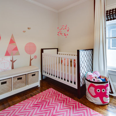 Example of a transitional girl dark wood floor nursery design in Minneapolis with beige walls