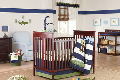 Photo of a nursery for boys in Los Angeles with white walls and light hardwood flooring.