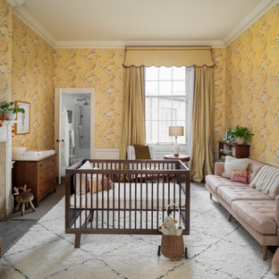 This is an example of an expansive traditional nursery for girls in Edinburgh with yellow walls, grey floors and wallpapered walls.