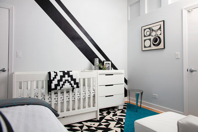Ejemplo de habitación de bebé niño contemporánea pequeña con paredes grises y suelo de madera clara