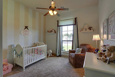 ニューオリンズにある低価格の中くらいなトランジショナルスタイルのおしゃれな赤ちゃん部屋 (青い壁、カーペット敷き、男女兼用、ベージュの床) の写真