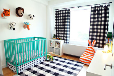 Nursery - contemporary gender-neutral medium tone wood floor nursery idea in New York with white walls