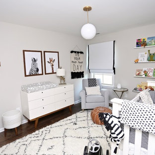 Example of a minimalist gender-neutral dark wood floor and brown floor nursery design in Other with gray walls