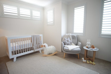 他の地域にある中くらいなコンテンポラリースタイルのおしゃれな赤ちゃん部屋 (グレーの壁、カーペット敷き、男の子用、ベージュの床) の写真