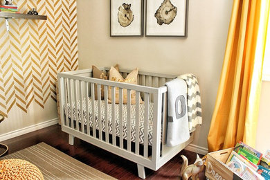 Diseño de habitación de bebé neutra contemporánea grande con paredes beige, suelo de madera oscura y suelo marrón