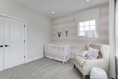 Imagen de habitación de bebé niña actual pequeña con paredes rosas y moqueta
