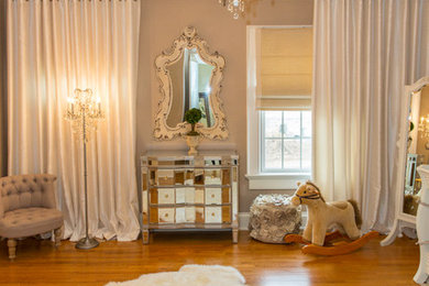 Example of a large classic gender-neutral medium tone wood floor nursery design in New York with beige walls