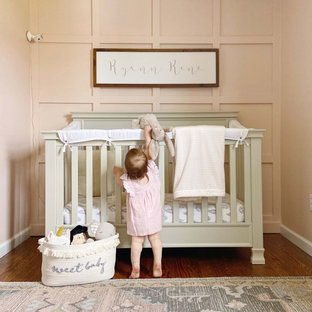 Small cottage girl medium tone wood floor nursery photo in Bridgeport with pink walls