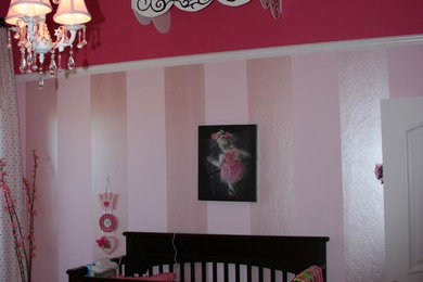 Diseño de habitación de bebé niña contemporánea de tamaño medio con paredes rosas, moqueta y suelo beige