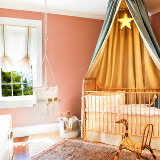 Ispirazione per una cameretta per neonata eclettica di medie dimensioni con pareti rosa, moquette e pavimento beige