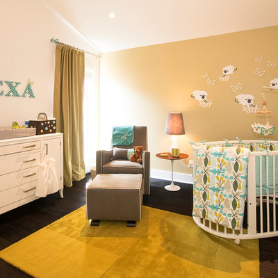Example of a trendy gender-neutral dark wood floor nursery design in Vancouver with beige walls