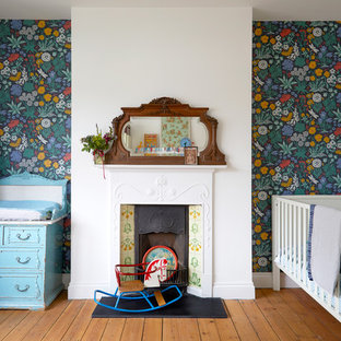 Design ideas for a bohemian gender neutral nursery in London with green walls, medium hardwood flooring and brown floors.