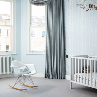 Inspiration for a contemporary nursery for boys in London with blue walls, carpet and grey floors.