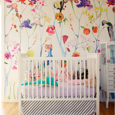 Nursery - small contemporary girl medium tone wood floor nursery idea in Seattle with multicolored walls