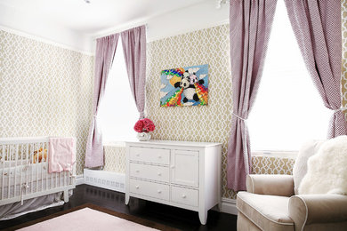 Photo of a traditional nursery for girls in New York with beige walls and dark hardwood flooring.