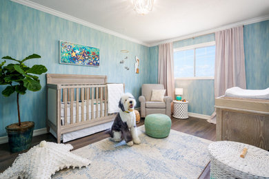 Nursery - coastal gender-neutral dark wood floor, brown floor and wallpaper nursery idea in Manchester with blue walls