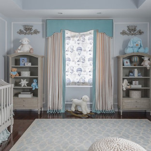 Foto di una cameretta per neonato minimal di medie dimensioni con pareti blu e parquet scuro