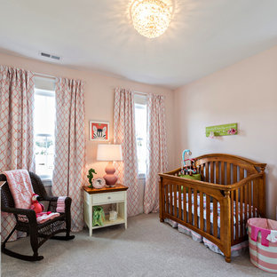 Mid-sized farmhouse girl carpeted nursery photo in Other with pink walls
