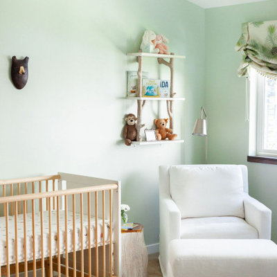 Trendy gender-neutral medium tone wood floor and brown floor nursery photo in Seattle with green walls