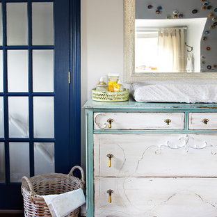 Esempio di una cameretta per neonati neutra shabby-chic style con pareti bianche e parquet scuro