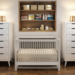Idee per una cameretta per neonato nordica con pareti beige e pavimento in compensato