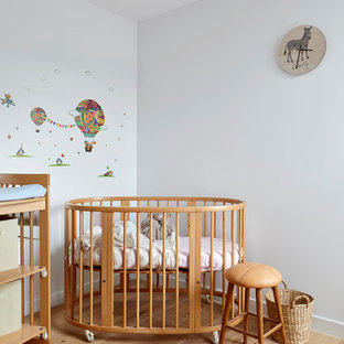 Design ideas for a small contemporary gender-neutral nursery in Melbourne with white walls, light hardwood floors and beige floor.