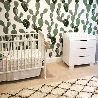 Immagine di una piccola cameretta per neonati neutra american style con pareti bianche, moquette e pavimento beige