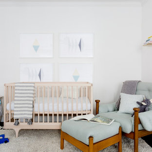Immagine di una cameretta per neonati neutra chic con pareti bianche, parquet scuro e pavimento marrone