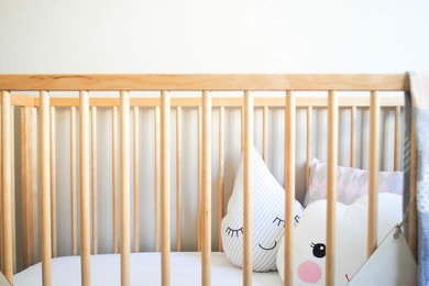 Imagen de habitación de bebé niña tradicional renovada pequeña con paredes blancas