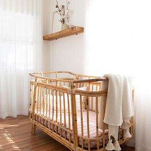 Photo of a beach style nursery for girls in Gold Coast - Tweed with beige walls and medium hardwood floors.