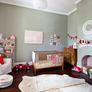 Large bohemian gender neutral nursery in Perth with grey walls, dark hardwood flooring and brown floors.
