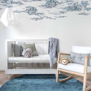 Photo of a contemporary gender-neutral nursery in Perth with multi-coloured walls, light hardwood floors, beige floor and wallpaper.