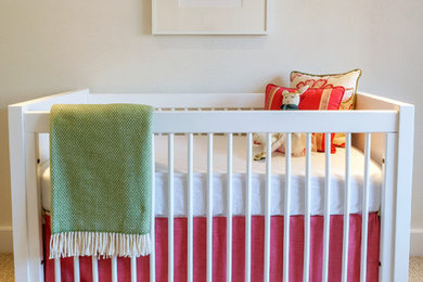 Example of a mid-sized minimalist girl carpeted nursery design in New York with beige walls