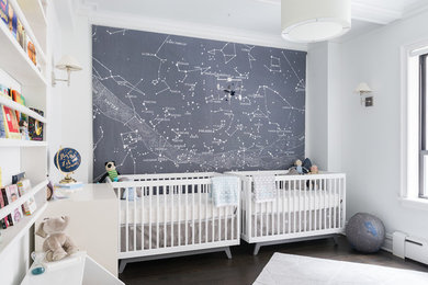 Imagen de habitación de bebé neutra actual con paredes grises, suelo de madera oscura y suelo marrón
