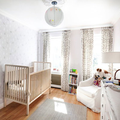 Nursery - mid-sized transitional gender-neutral medium tone wood floor and beige floor nursery idea in New York with gray walls