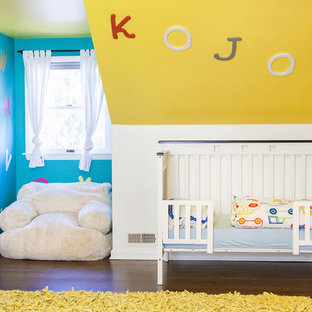 Nursery - eclectic gender-neutral dark wood floor and brown floor nursery idea in Columbus with yellow walls