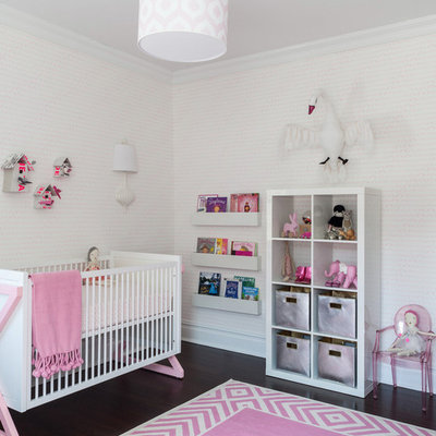 Trendy girl dark wood floor nursery photo in New York with white walls