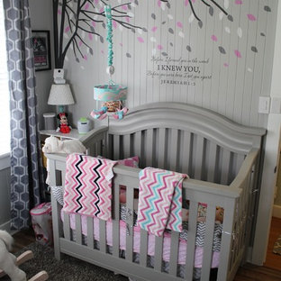Ispirazione per una piccola cameretta per neonata stile marino con pareti grigie, pavimento in laminato e pavimento grigio