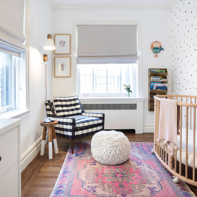 Nursery - small transitional girl brown floor and dark wood floor nursery idea in New York with white walls