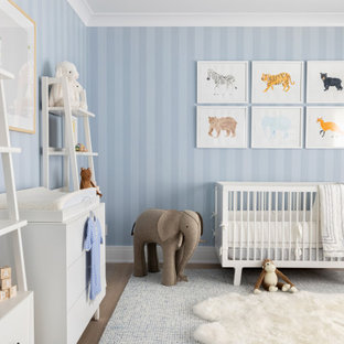 Esempio di una grande cameretta per neonato classica con pareti blu, parquet chiaro e pavimento marrone