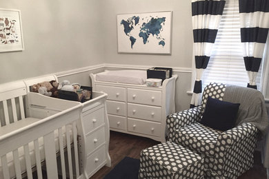 Diseño de habitación de bebé neutra tradicional renovada de tamaño medio con paredes grises y suelo de madera oscura