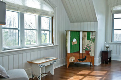 Diseño de habitación de bebé neutra de tamaño medio con paredes blancas y suelo de madera clara