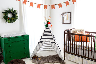 Cette photo montre une chambre de bébé neutre éclectique de taille moyenne avec un mur blanc et parquet peint.