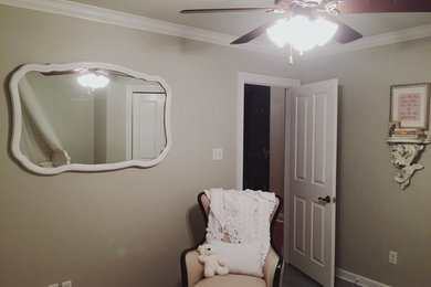ニューオリンズにある低価格の中くらいなシャビーシック調のおしゃれな赤ちゃん部屋 (グレーの壁、コンクリートの床、男女兼用) の写真