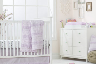 Foto de habitación de bebé niña de tamaño medio con paredes grises, suelo de madera clara y suelo beige