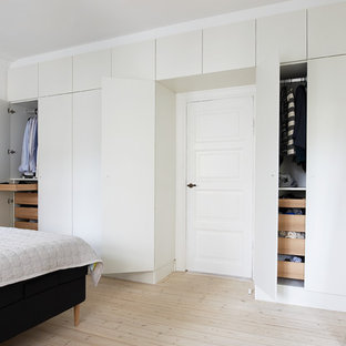 Modelo de armario unisex, nórdico, con armarios con paneles lisos, puertas de armario blancas y suelo de madera clara